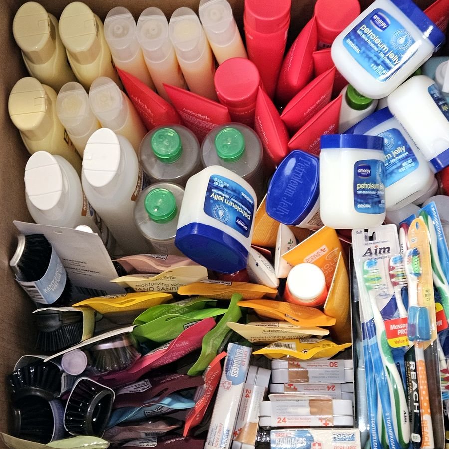 A box of lotion, shampoo, toothbrushes and other hygiene supplies