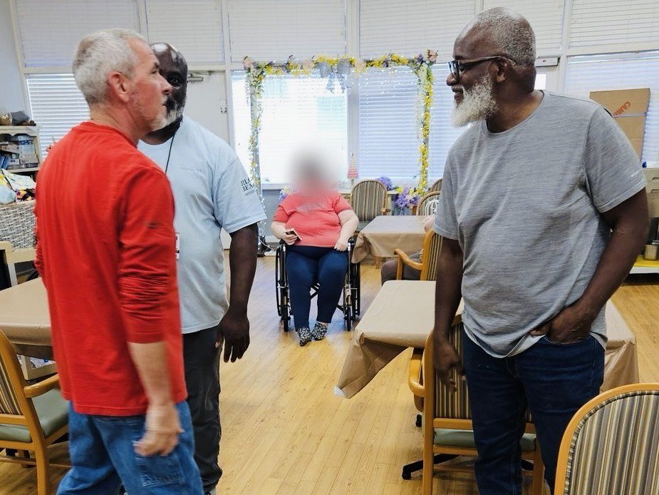Volunteers visiting with residents in a nursing-home activity room
